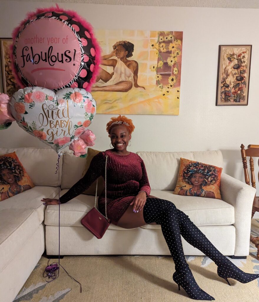 NeNe dressed in a short, long sleeved dark red, sparkly dress and thigh high sparkly black boots on her birthday!
